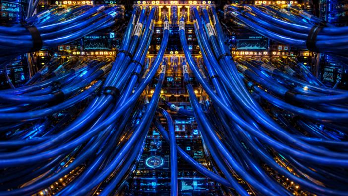 Network cabling converging into a lit patch panel