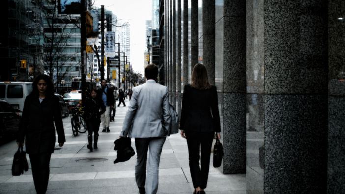 Two colleagues walking through a financial district